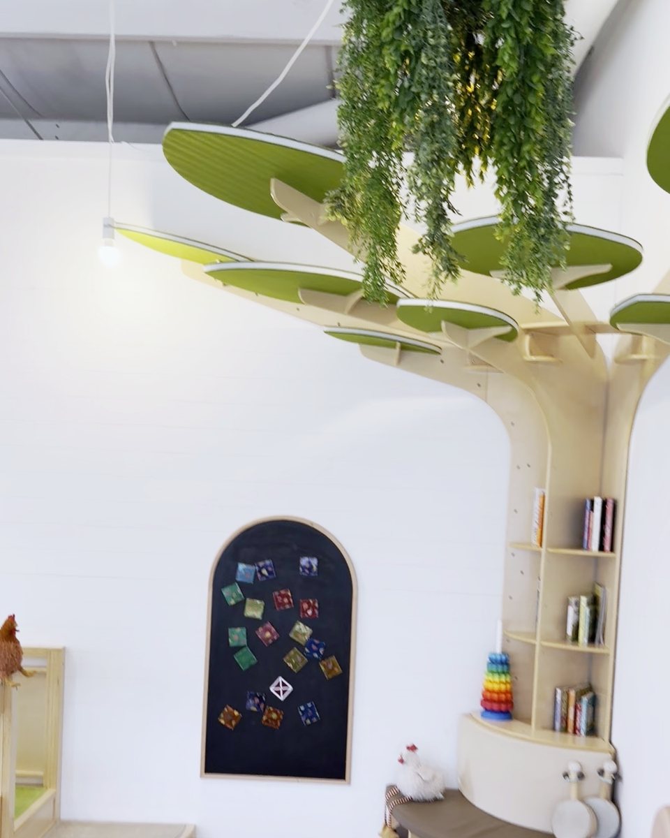 Reading nook built into a wooden tree with hanging greenery